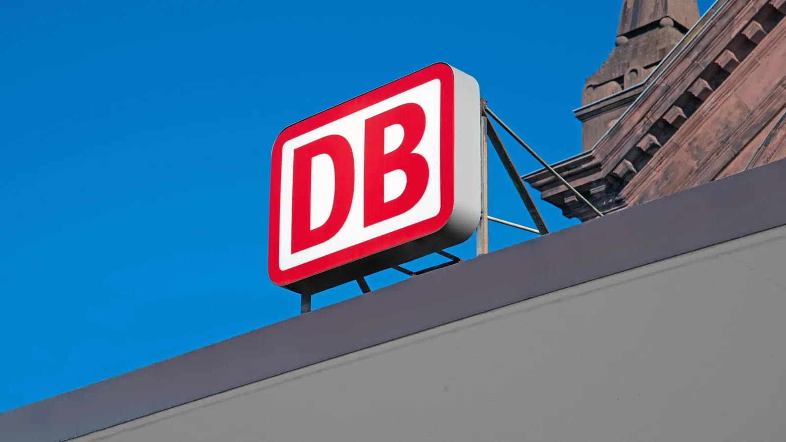Das bekannte Logo der Deutschen Bahn (DB) am Bahnhofseingang.