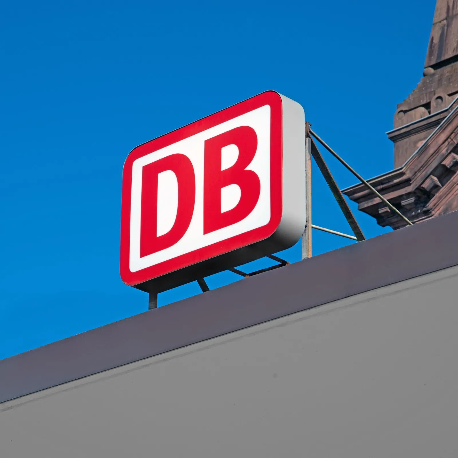 Das bekannte Logo der Deutschen Bahn (DB) am Bahnhofseingang.