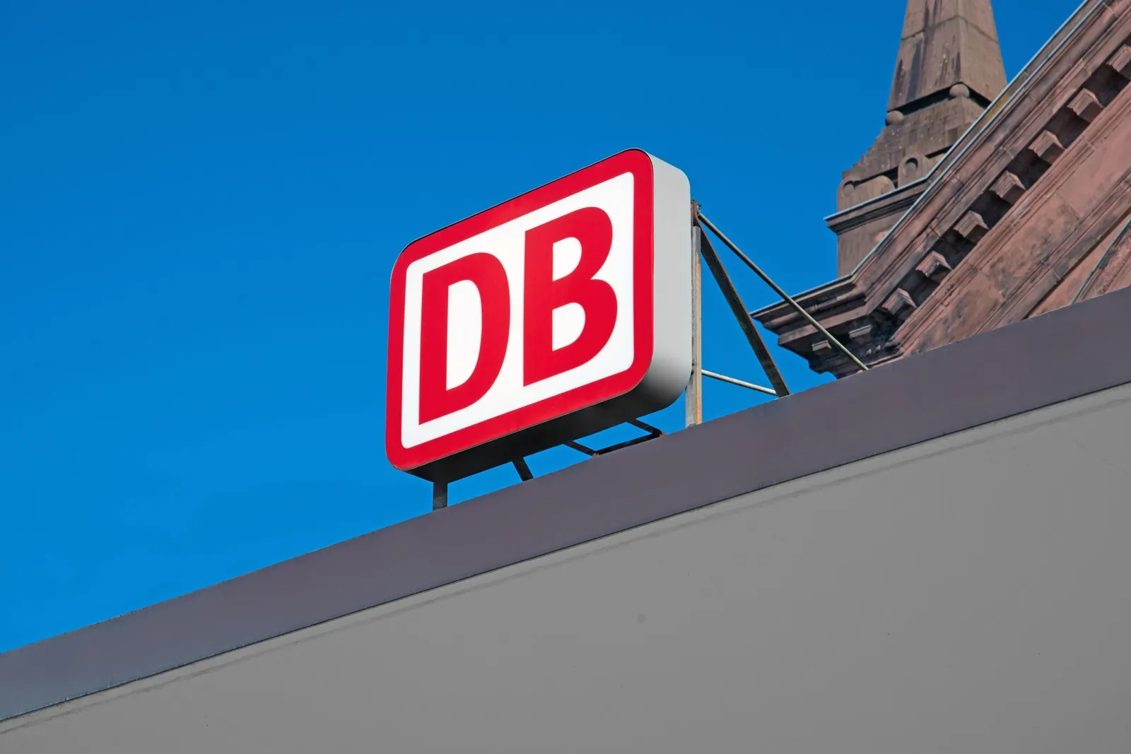 Das bekannte Logo der Deutschen Bahn (DB) am Bahnhofseingang.