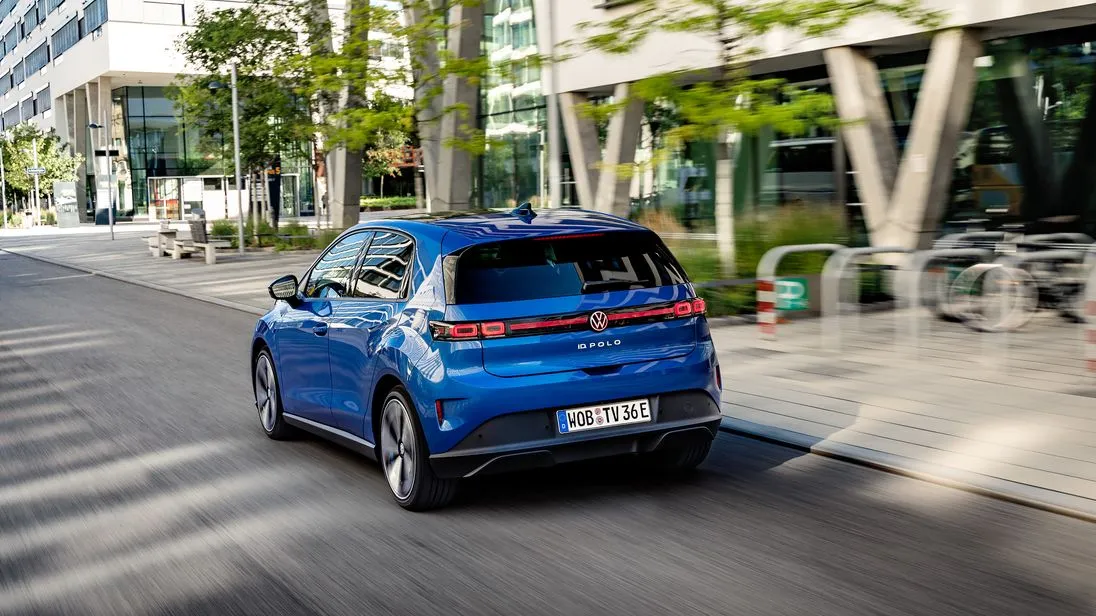 Der elektrisch angetriebene Polo fährt an einer Bürofront vorbei.