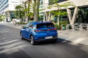 Der elektrisch angetriebene Polo fährt an einer Bürofront vorbei.