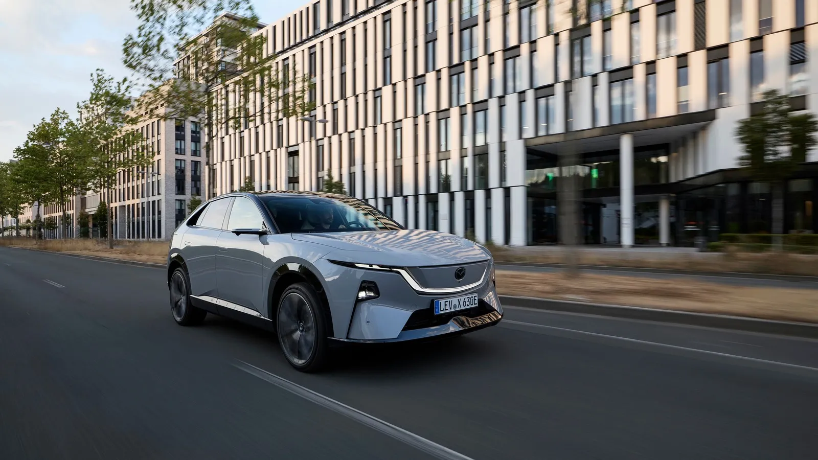 Der Mazda CX 6e fährt durch die Stadt.