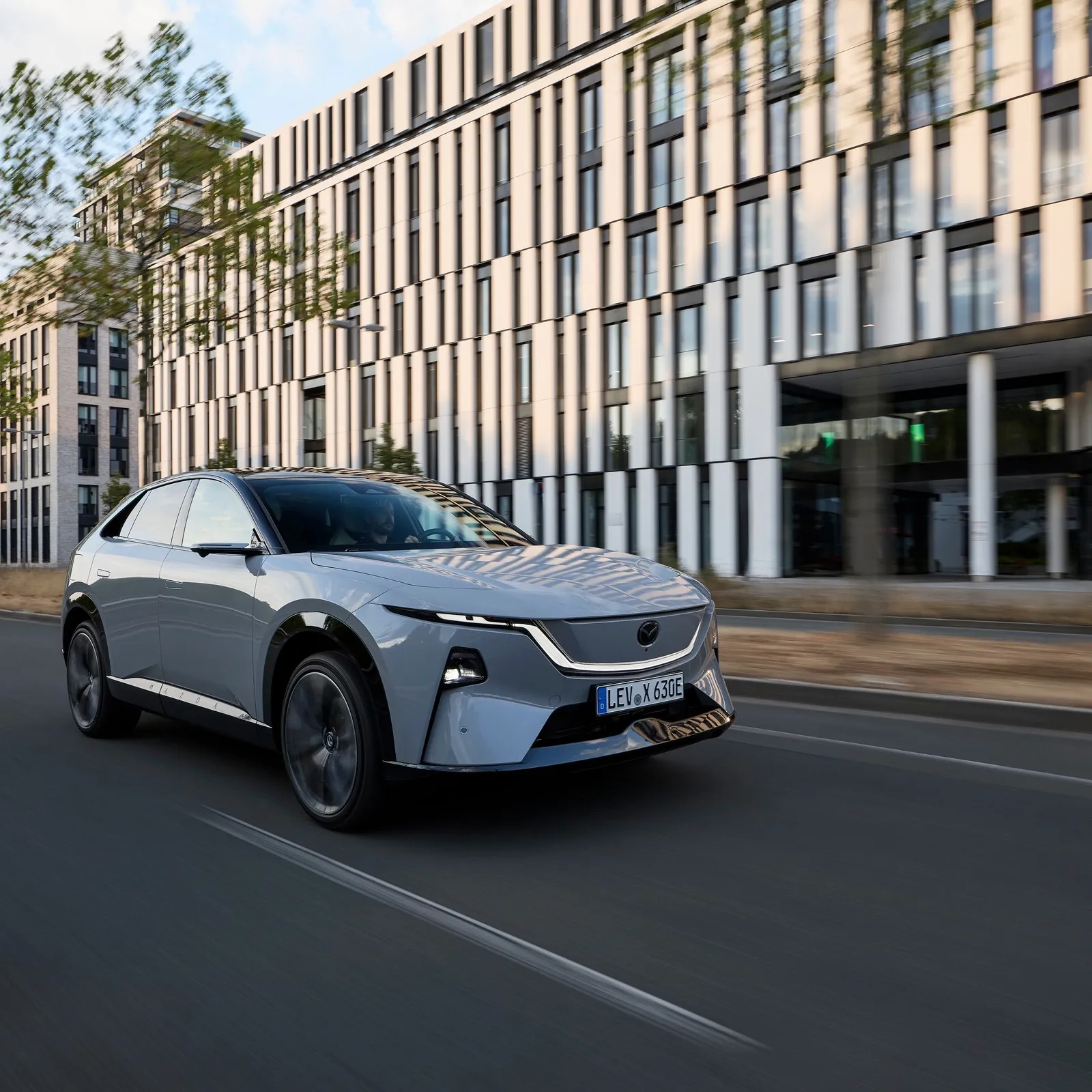 Der Mazda CX 6e fährt durch die Stadt.