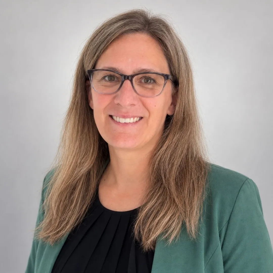 Nathalie Wilms lacht in die Kamera und trägt einen grünen Blazer.