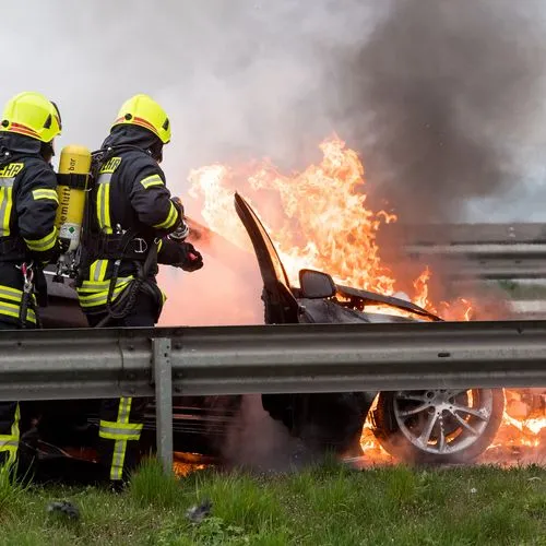 Die Feuerwehr versucht einen Autobrand zu löschen.