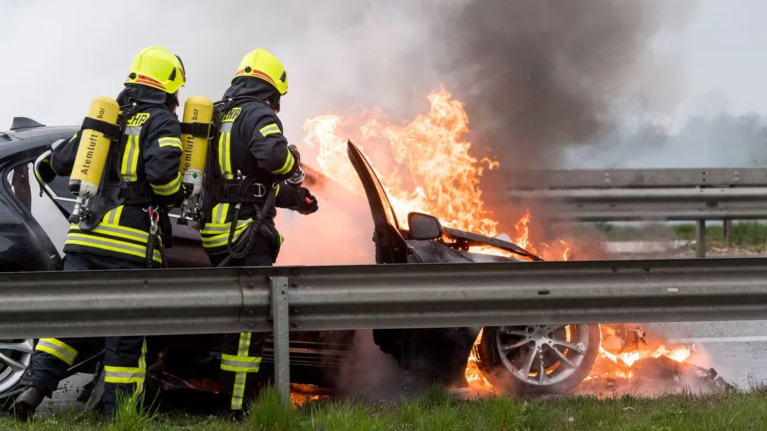 Die Feuerwehr versucht einen Autobrand zu löschen.