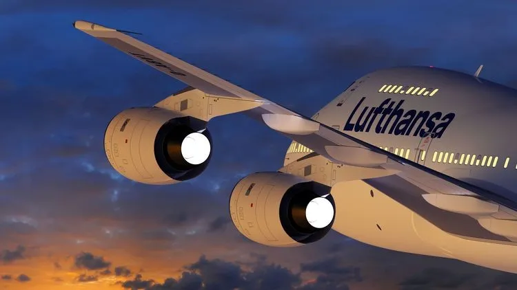 Ausschnitt eines aufsteigenden Flugzeugs der Lufthansa bei Sonnenuntergang.