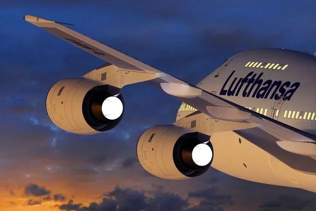 Ausschnitt eines aufsteigenden Flugzeugs der Lufthansa bei Sonnenuntergang.