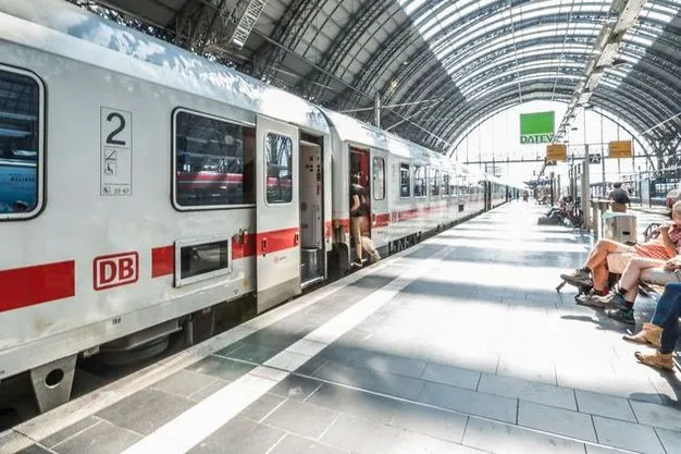 Ein Zug der Deutschen Bahn steht in einem Bahnhof und Leute steigen ein.