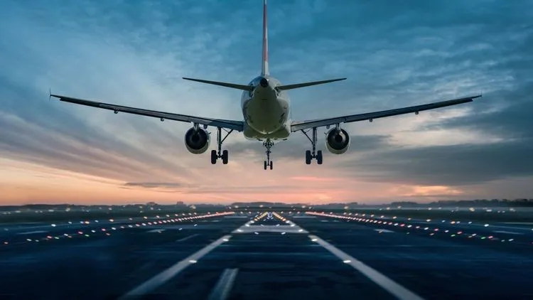 Ein Flugzeug fliegt im Sinkflug auf eine Landebahn zu.