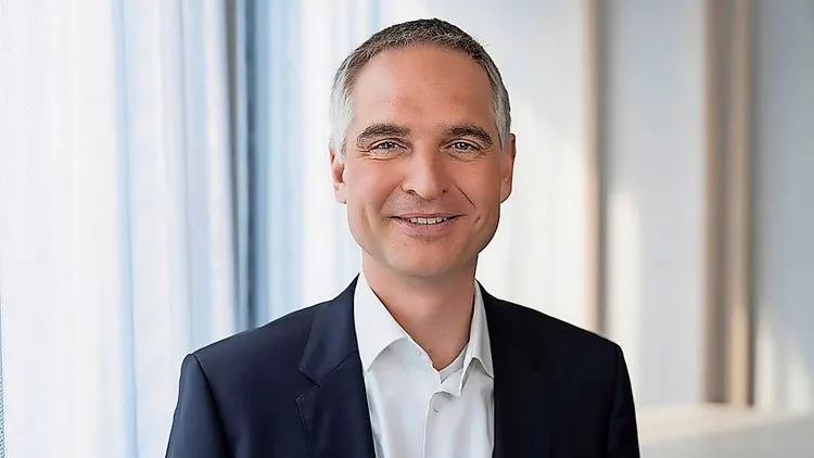 Steffen Krautwasser lächelt in Richtung Kamera und trägt einen Anzug.