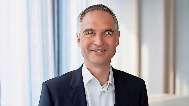 Steffen Krautwasser lächelt in Richtung Kamera und trägt einen Anzug.