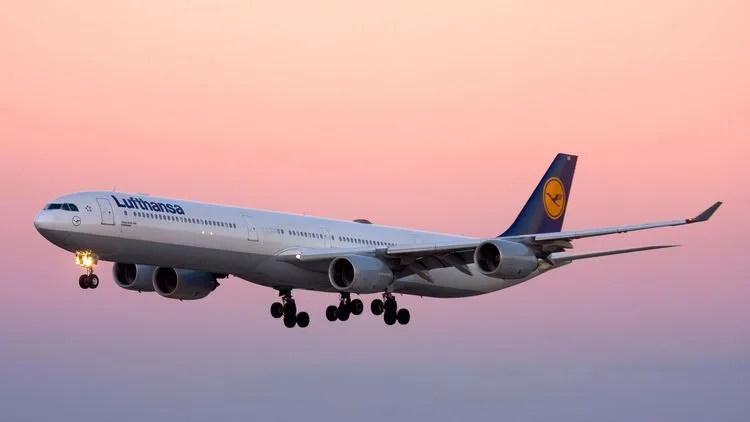 Ein Flugzeug der Lufthansa fliegt bei klarem Himmel.