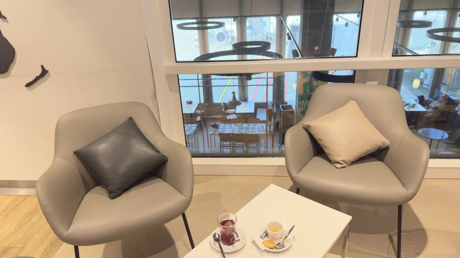 Entspannte Sitzmöglichkeiten mit Tischen auf zwei Ebenen in der DUS Rhein Lounge.