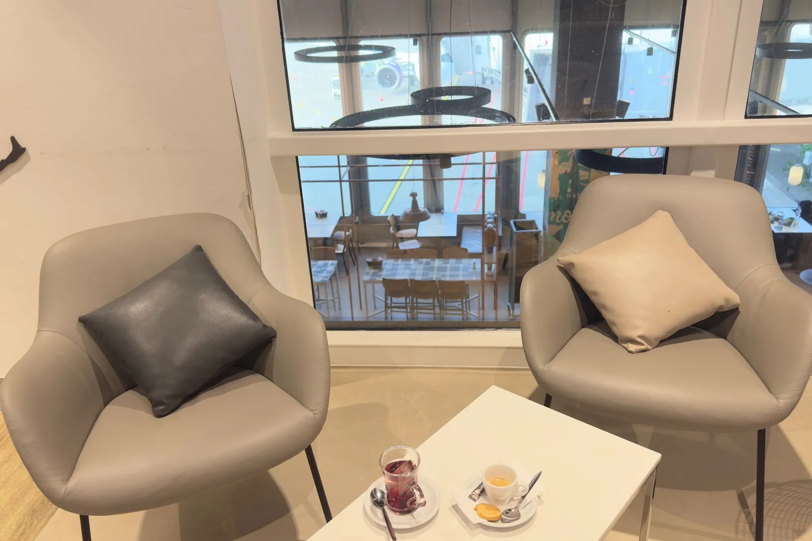 Entspannte Sitzmöglichkeiten mit Tischen auf zwei Ebenen in der DUS Rhein Lounge.
