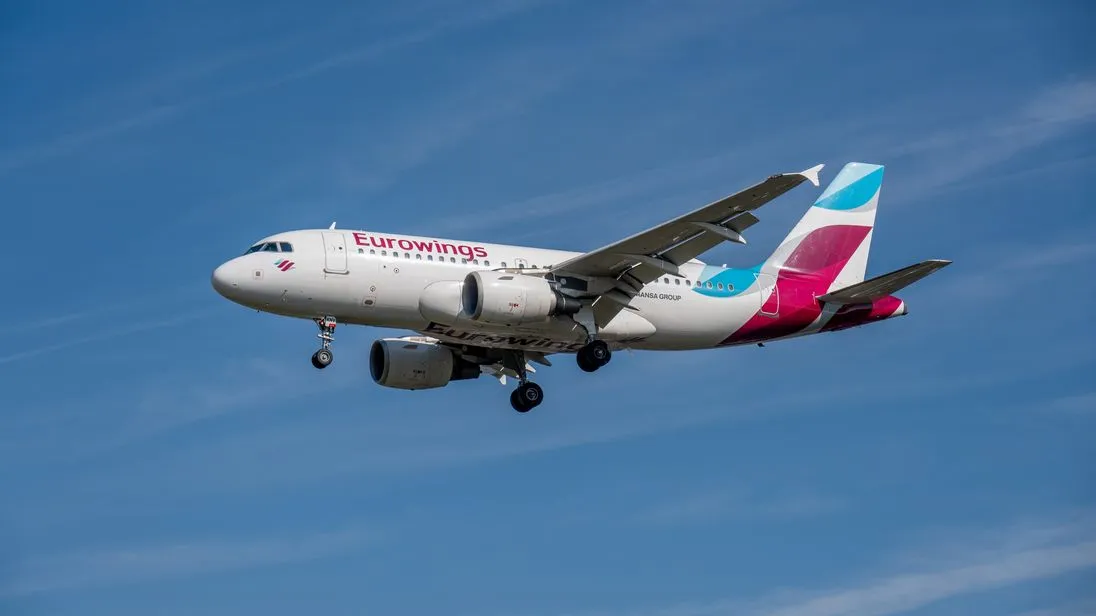Ein Flugzeug von Eurowings fliegt bei blauem Himmel.