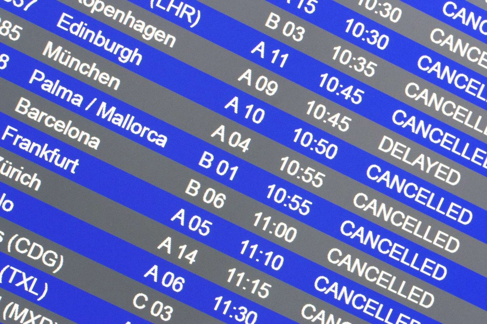Anzeigetafel an einem Flughafen mit mehreren annullierten und verspäteten Flügen.