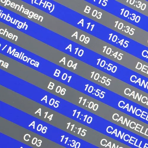 Anzeigetafel an einem Flughafen mit mehreren annullierten und verspäteten Flügen.