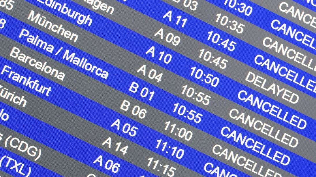 Anzeigetafel an einem Flughafen mit mehreren annullierten und verspäteten Flügen.