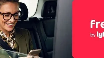 Geschäftsfrau im Auto mit Smartphone
