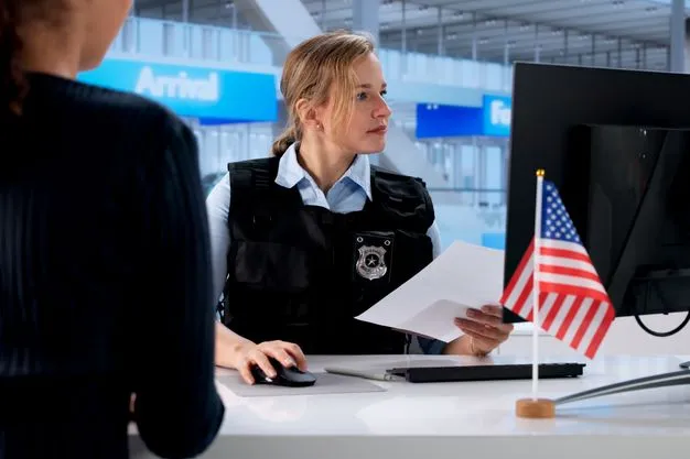 Sicherheitsbeamtin in Uniform bei der Dokumentenkontrolle an einem US-Grenzschalter. Im Vordergrund eine US-Flagge, im Hintergrund Flughafen-Terminal. Symbolbild für die verschärften Sicherheitsmaßnahmen und verstärkten Kontrollen bei der Einreise in die USA 2026.