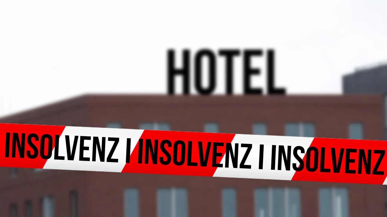 Hotel im Hintergrund und vorne ein rot-weißes Absperrband mit den Worten "Insolvenz".