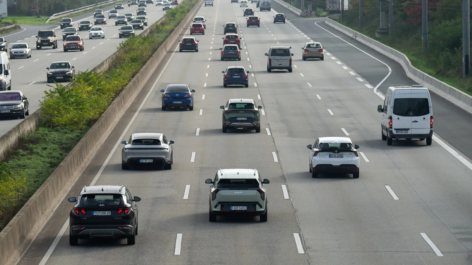 Verschiedene Autos fahren auf einer Autobahn mit vier Fahrstreifen.