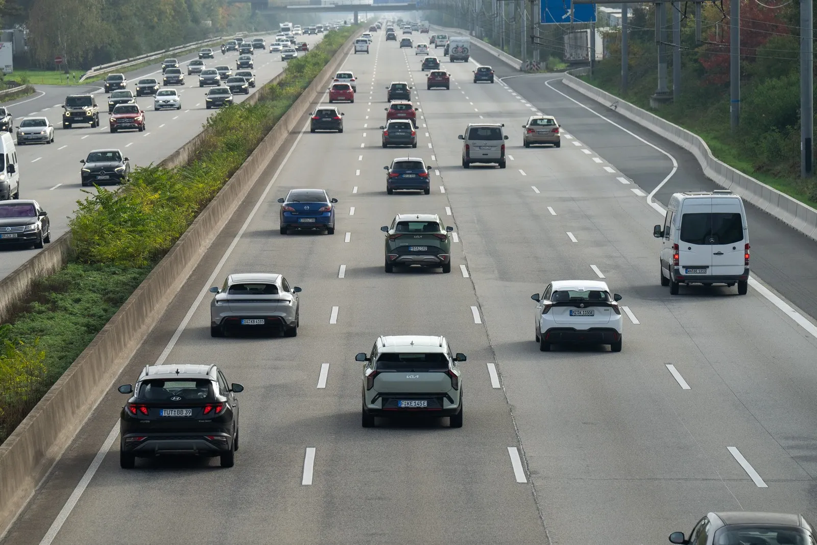 Verschiedene Autos fahren auf einer Autobahn mit vier Fahrstreifen.