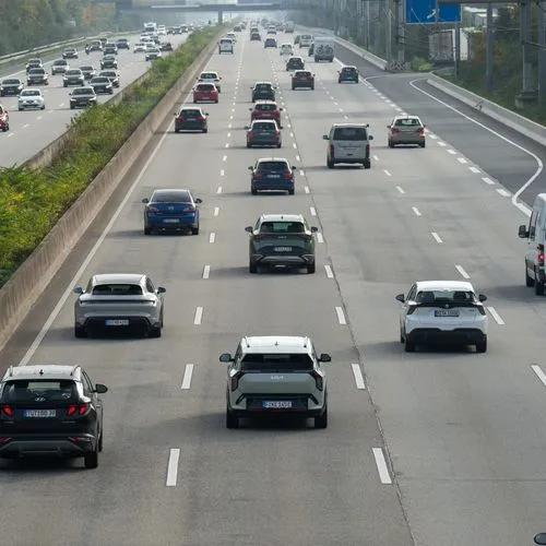 Verschiedene Autos fahren auf einer Autobahn mit vier Fahrstreifen.