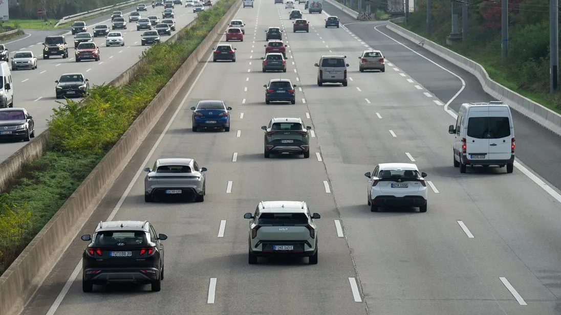 Verschiedene Autos fahren auf einer Autobahn mit vier Fahrstreifen.