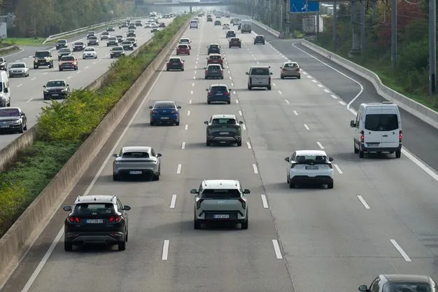 Verschiedene Autos fahren auf einer Autobahn mit vier Fahrstreifen.