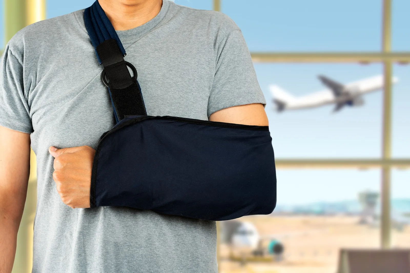 Mann mit gebrochenen Arm am Flughafen.