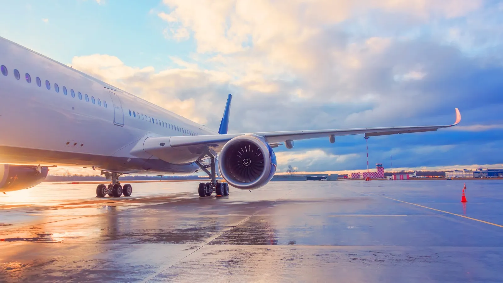 Abendlicher Blick auf die Tragfläche eines Passagierflugzeugs mit Triebwerk.