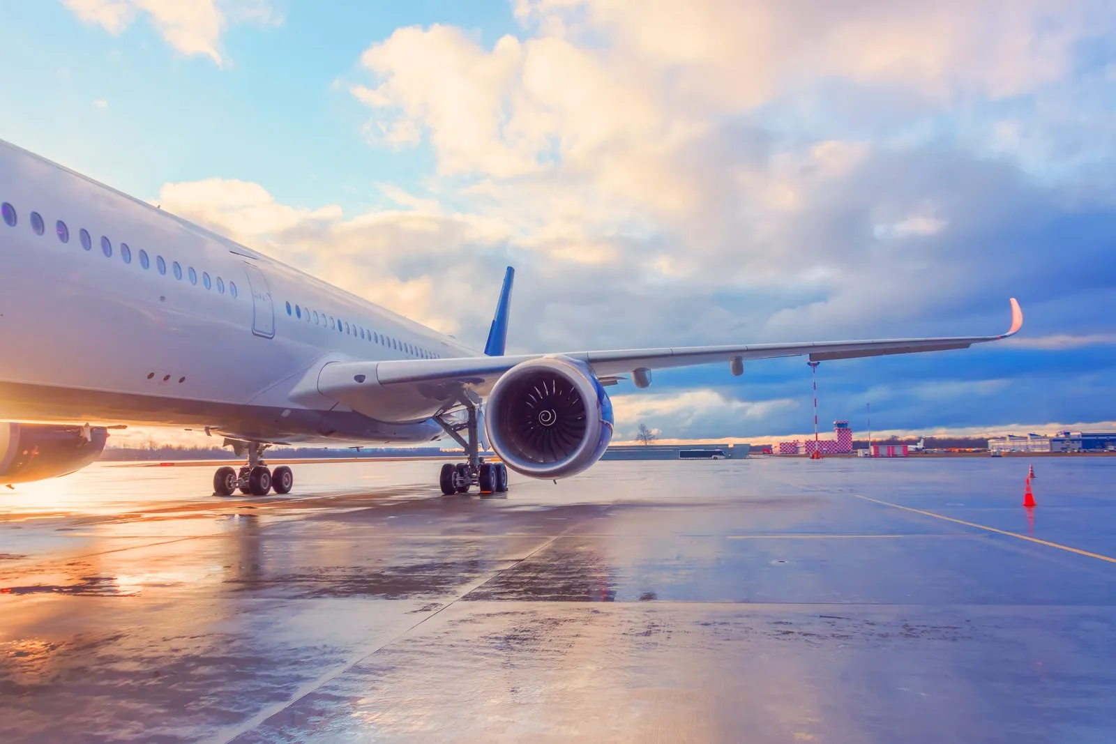 Abendlicher Blick auf die Tragfläche eines Passagierflugzeugs mit Triebwerk.