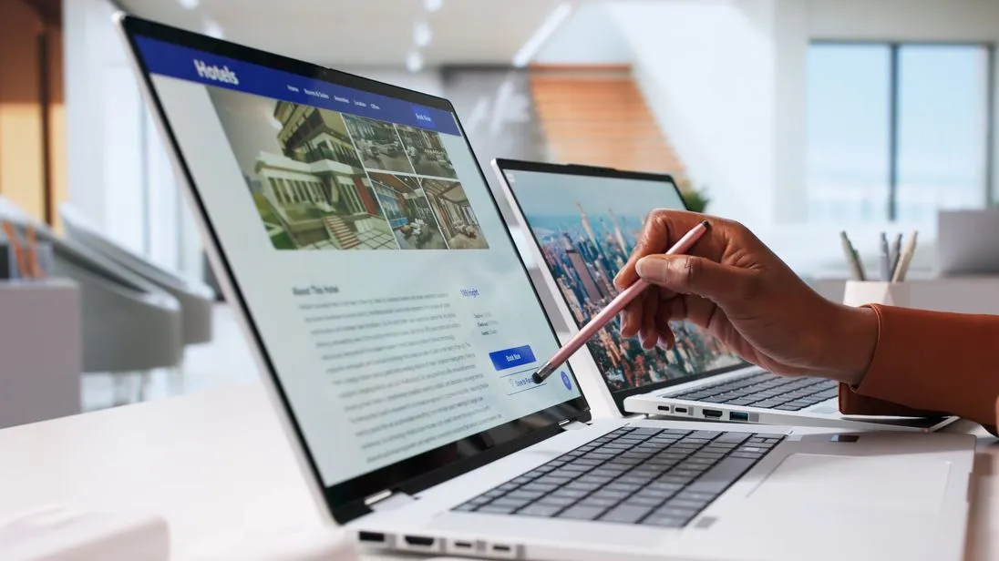 Eine Hand zeigt mit einem Stift auf einen Laptop. Auf dem Laptop ist eine Hotel-Buchungsseite geöffnet.