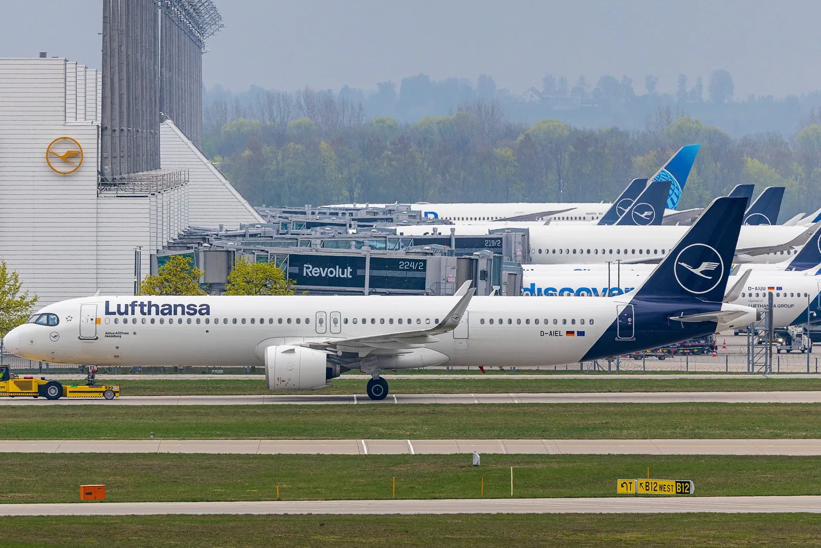 Ein Flugzeug der Lufthansa wird am Flughafen München mit einem Schlepper auf dem Vorfeld abgestellt.