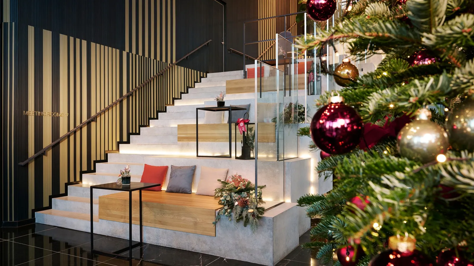 Im NH Minor Hotel in Frankfurt ist die Treppe schön weihnachtlich mit Christbaum, Kissen und Lichtern dekoriert.