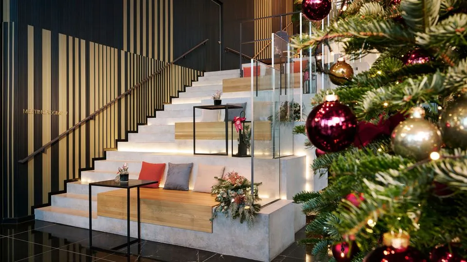 Im NH Minor Hotel in Frankfurt ist die Treppe schön weihnachtlich mit Christbaum, Kissen und Lichtern dekoriert.