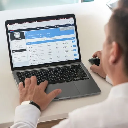 Mann nutzt am Laptop ein digitales Buchungstool für Flugreisen.